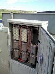 Ein geffneter Schaltverteiler neben einem Telekom-Technikgehuse (links im Bild)