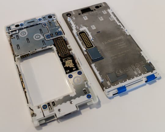Das FairPhone 2 auseinandergenommen: Links das Grundmodul mit weiteren austauschbaren Teilen, rechts ist das Display zu sehen.