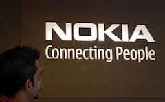 Ein Mann blickt auf das Firmen-Logo von Nokia.