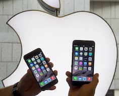 Ein Mann hlt am 19.09.2014 im Apple-Store in Mnchen (Bayern) zwei Iphone 6 Modelle vor das Apple-Logo.