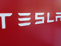 Der Schriftzug Tesla auf einem roten Hintergrund.