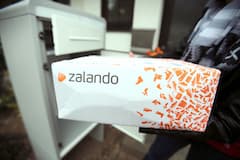 Eine Frau hlt ein Paket des Online-Versandhndlers fr Schuhe und Mode, Zalando.