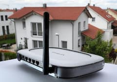 Ein WLAN-Router steht vor einem Haus.