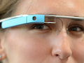 Eine junge Frau trgt ein Google Glass auf einem Brillenrahmen.