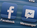 uf dem Display eines iPhones sind die App-Logos von Facebook und Messenger zu sehen.
