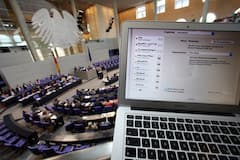 Die Parlamentarier des Deutschen Bundestages debattieren im Hintergrund. Im Vordergrund ist das Laptop eines Journalisten zu sehen.