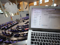 Die Parlamentarier des Deutschen Bundestages debattieren im Hintergrund. Im Vordergrund ist das Laptop eines Journalisten zu sehen.