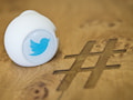 Ein Gadget mit dem Logo des Kurznachrichtendienstes Twitter liegt am 29.06.2015 in Hamburg in einem Bro von Twitter Deutschland auf einem Besprechungstisch mit dem eingraviertem Zeichen "Hashtag".