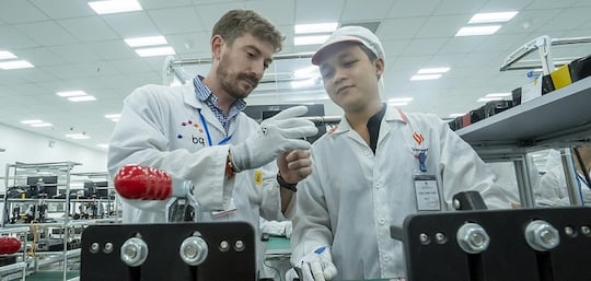Gemeinsame Arbeit europischer und vietnamesischer Mitarbeiter in der Smartphone-Fabrik