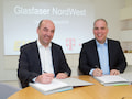 Stefan Dohler (l.), Vorstandsvorsitzender der EWE AG, und Dirk Wssner, Vorstand Telekom Deutschland, unterzeichnen den Vertrag fr Glasfaser NordWest