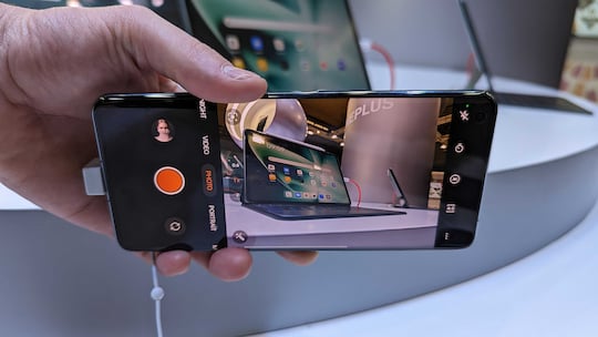 OnePlus 11 mit geffneter Kamera-App (im Hintergrund: Das OnePlus Pad)