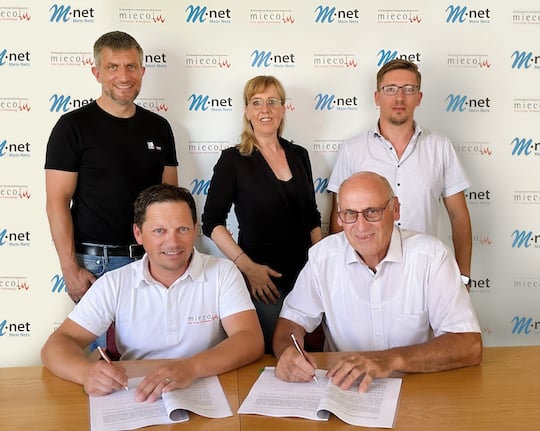 Anton Winkler, 1. Brgermeister von Binswangen (vorne rechts) unterzeichnet zusammen mit Tobias Miel von miecom den Vertrag fr den geplanten Glasfaserausbau